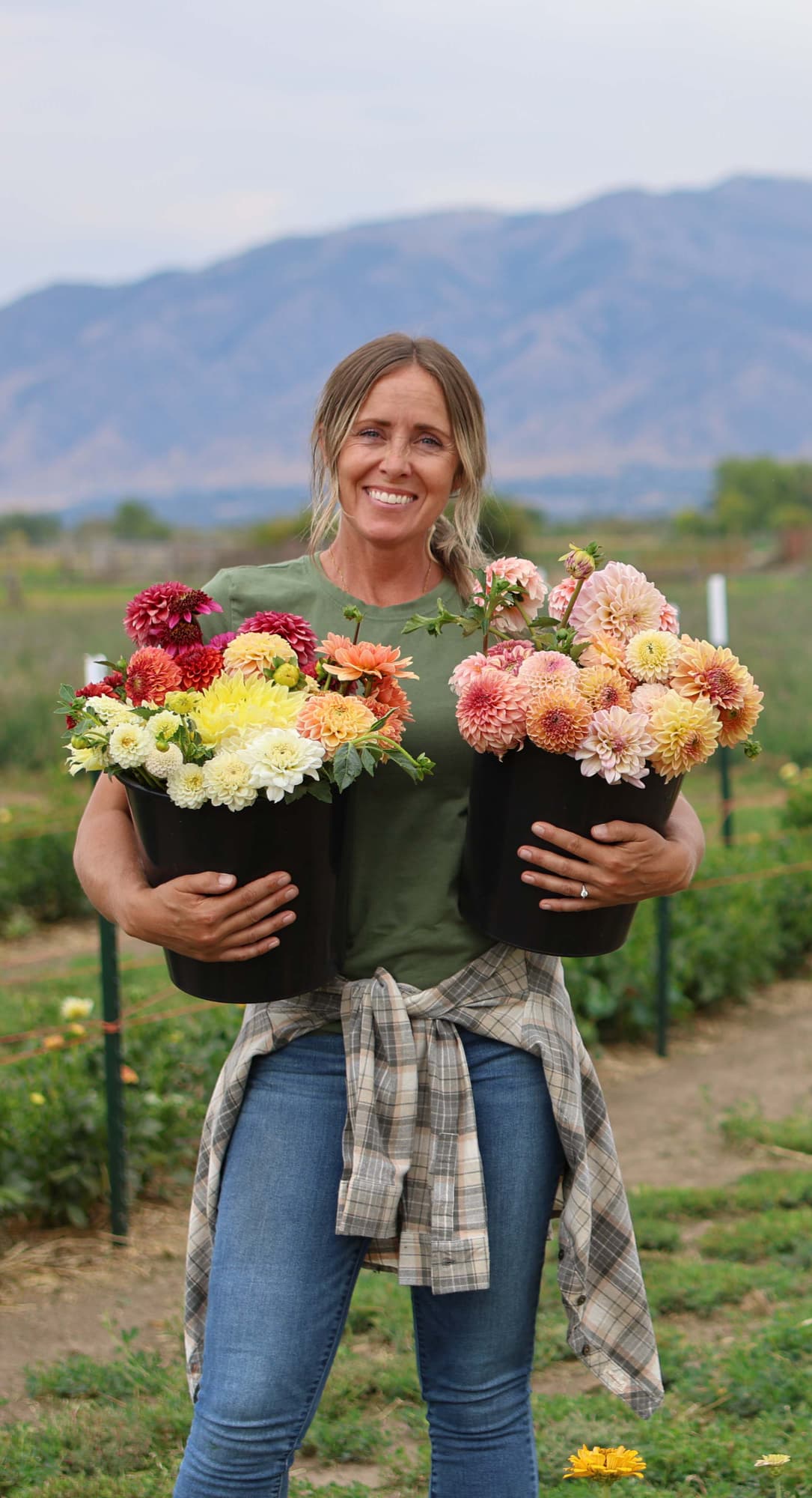 Jodie Norton holding buckets of freshly cut dahlias
